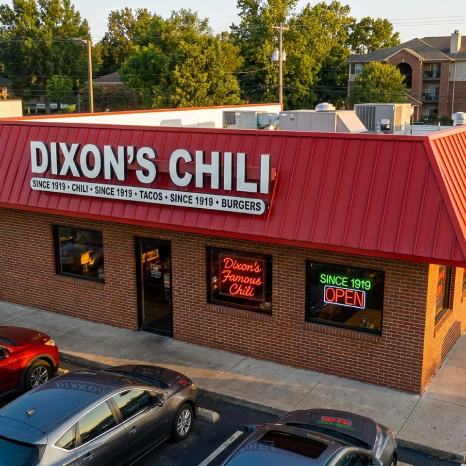 Aerial view of Dixon's Chili restaurant, a brick building with a red roof and parked cars.